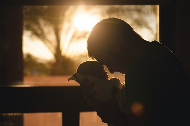 Un homme et son bébé dans le soleil couchant